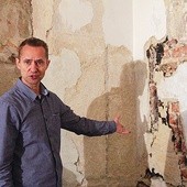 Piotr Jabłoński, konserwator dzieł sztuki i wykonawca prac, wskazuje odkryte polichromie. W tym miejscu postać świętego 