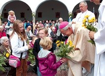 Biskup L. Schick przyjmuje od dzieci i młodzieży kwiaty i dary ołtarza