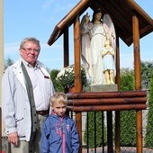 Benedykt Chojnacki z wnukiem Jasiem przy kapliczce, którą wykonali