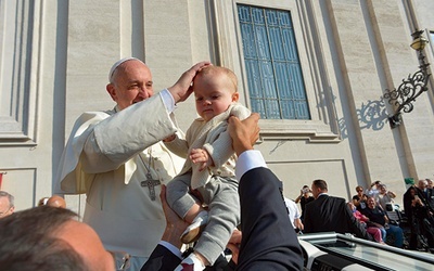  8 października 2014, watykan. Papież Franciszek błogosławi dziecko podane mu przez osobę stojącą w tłumie wiernych w czasie środowej audiencji na placu Świętego Piotra. W Watykanie trwa synod o rodzinie.