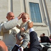  8 października 2014, watykan. Papież Franciszek błogosławi dziecko podane mu przez osobę stojącą w tłumie wiernych w czasie środowej audiencji na placu Świętego Piotra. W Watykanie trwa synod o rodzinie.