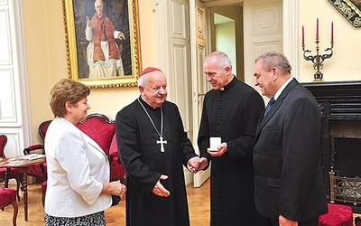   Kard. S. Dziwisz przekazuje relikwie ks. B. Karpowi i państwu Budkom