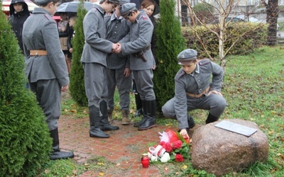 Kwiaty i znicze pod kamieniem obok Dębu Katyńskiego od młodzieży szkolnej