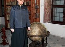 Ks. Sebastian Kazimirski prezentuje globus kosmosu z klasztornej biblioteki