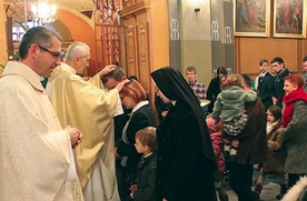Indywidualne błogosławieństwo rodzin po Eucharystii. Na zdjęciu ks. F. Płonka  modli się nad M. i R. Bielickimi.  Z lewej ks. T. Gorczyński 