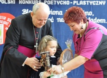 Ks. inf. Władysław Kostrzewa i Jadwiga Bieś wręczają nagrodę najmłodszej uczestniczce konkursu