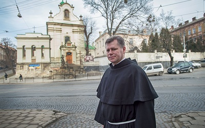 O. dr Stanisław Kawa przed kościołem św. Antoniego, za drzewami budynek  b. klasztoru, o który toczy się spór 