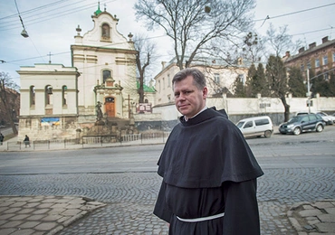 O. dr Stanisław Kawa przed kościołem św. Antoniego, za drzewami budynek  b. klasztoru, o który toczy się spór 