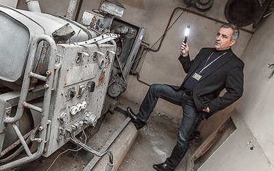 Janusz Frystacki pokazuje generator prądu, który miał zapewnić m.in. doprowadzanie oczyszczonego powietrza do wnętrza schronu