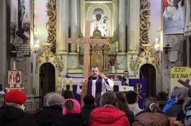 Ks. Przemysław Sawa trzyma krzyż z wbitymi gwoździami synbolizującymi ludzkie grzechy