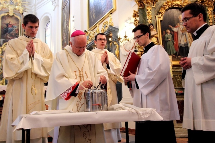 Bp Andrzej F. Dziuba wlewa balsam do naczynia z olejem krzyżma