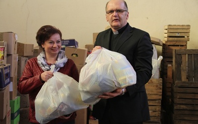 Ks. Grzegorz Wójcik i Iwona Stępniewska, pracownik Caritas, przy wydawaniem paczek