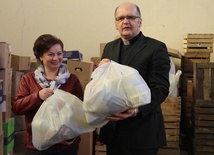 Ks. Grzegorz Wójcik i Iwona Stępniewska, pracownik Caritas, przy wydawaniem paczek