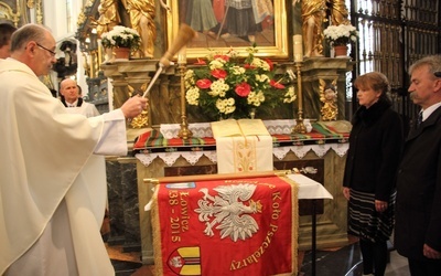 Ks. Wiesław Skonieczny święci sztandar łowickiego koła pszczelarzy. Obok Agnieszka Krajewska i Krzysztof Jan Kaliński