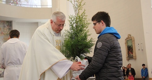 Ks. Jacek Skrobisz przyjmuje iglak - symbol troski parafian o wzrost i wierność każdego powołania