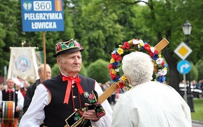 Mieszkanka Łowicza całuje pielgrzymkowy krzyż