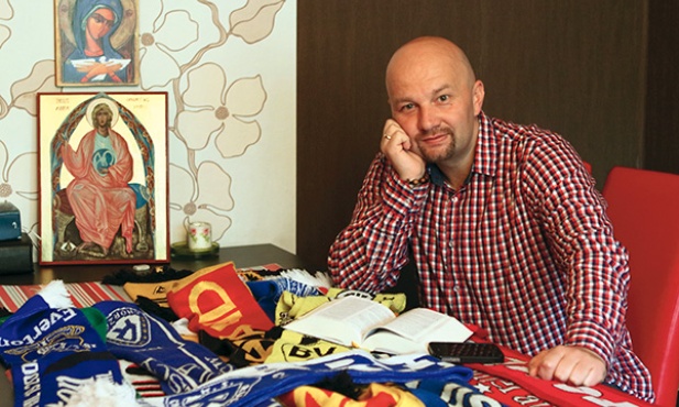 – Wstaję o czwartej, robię kawę i czytam Biblię. Czterdzieści  minut – opowiada Grzegorz Baraniok. Na stole mnóstwo szalików drużyn piłkarskich,  w tym ukochanego Ruchu