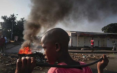 29.05.2015. Burundi, Bużumbura. Burundyjski chłopak obok płonących barykad podczas antyrządowej demonstracji przeciwko prezydentowi. Pierre Nkurunziza kandyduje po raz trzeci w wyborach na ten urząd, co budzi zastrzeżenia opozycji.