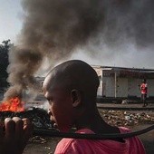 29.05.2015. Burundi, Bużumbura. Burundyjski chłopak obok płonących barykad podczas antyrządowej demonstracji przeciwko prezydentowi. Pierre Nkurunziza kandyduje po raz trzeci w wyborach na ten urząd, co budzi zastrzeżenia opozycji.