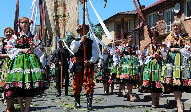 Procesja przebiega drogą usłaną tatarakiem