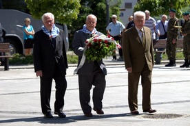 Byli więźniowie podczas składania kwiatów pod pomnikiem Orła Białego