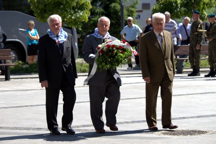 Byli więźniowie podczas składania kwiatów pod pomnikiem Orła Białego