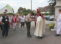Bp Rudolf Pierskała wita przed kościołem przewodnika z pielgrzymami