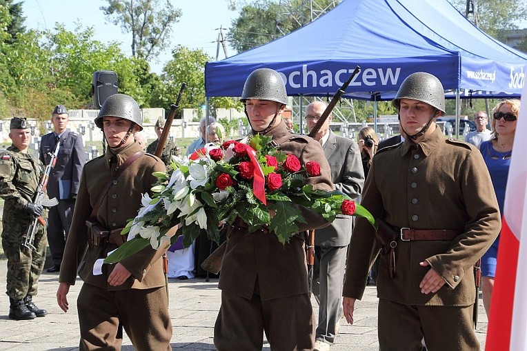 Członkowie Muzealnej Grupy Rekonstrukcji Historycznej II Batalionu 18. Pułku Piechoty skladają kwiaty pod pomnikiem na cmentarzu wojennym w Sochaczewie