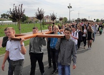 Młodzież z krośniewickich szkół podąża za symbolami w drodze z hali sportowej do kościoła