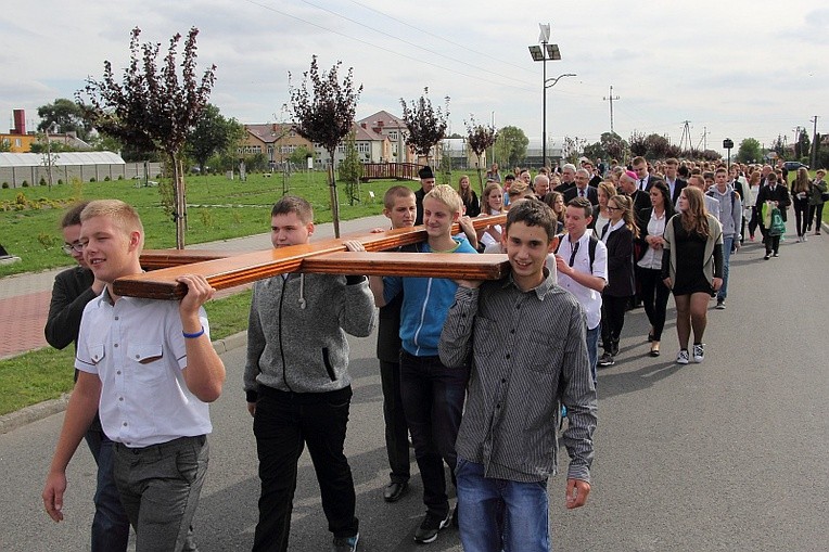 Młodzież z krośniewickich szkół podąża za symbolami w drodze z hali sportowej do kościoła