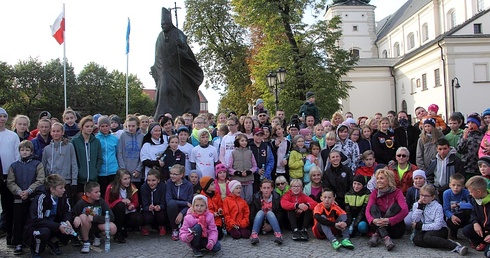 Uczestnicy biegu przed pomnikiem Jana Pawła II na Starym Rynku w Łowiczu