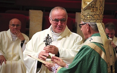 W imieniu Franciszka Pieczki statuetkę odbiera z rąk abp. Wiktora Skworca ks. Krzysztof Wrodarczyk, proboszcz z Godowa