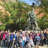 Uczestnicy wycieczki przy rzeźbie smoka wawelskiego w Krakowie