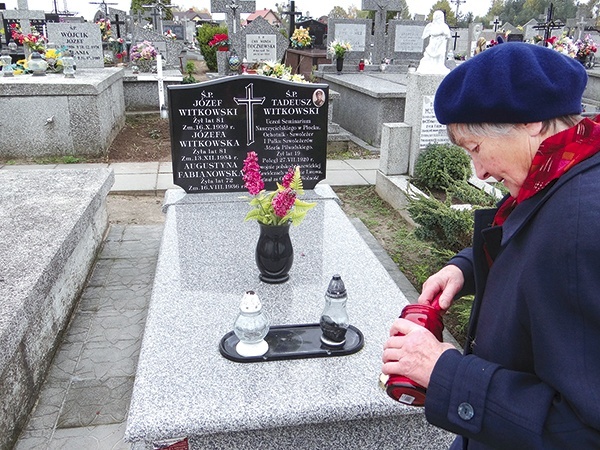 Krystyna Wyżykowska zapala znicz na pomniku grobowym swoich dziadków, na którym upamiętniony został jej wuj Tadeusz Witkowski (poniżej  na zdjęciu) 