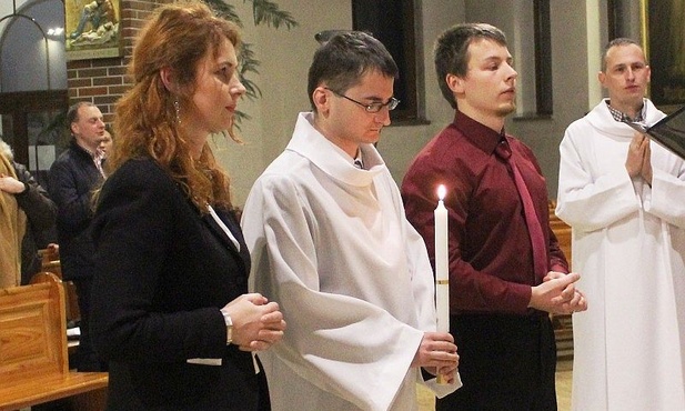 Kamil Łaciak w białej szacie chrzcielnej ze swoimi rodzicami chrzestnymi