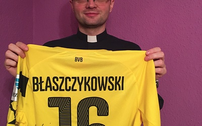 Ksiądz Krzysztof Misiuda z koszulką Kuby Błaszczykowskiego na licytację