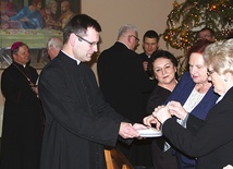 Ks. Andrzej Jędrzejewski, diecezjalny asystent kościelny AK, rozdaje opłatki poświęcone przez ordynariusza