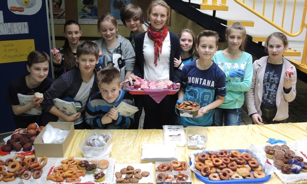 Katarzyna Heczko z uczniami zaangażowanymi w sprzedaż babeczek i pączków