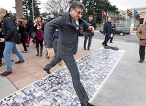 Salim al-Muslat, rzecznik Wysokiego Komitetu Negocjacyjnego, przed nagocjacjami w Genewie przechodzi nad zdjęciami ofiar wojny w Syrii  