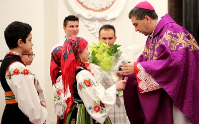 Bp Wojciech Osial przyjmuje kwiaty od dzieci ze Szkoły Podstawowej w Zielkowicach