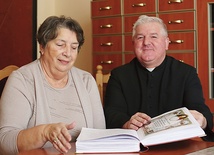  Ks. prał. Stanisław Morawa i Maria Satława nad kroniką parafii rozmawiają o nadchodzącym wydarzeniu 
