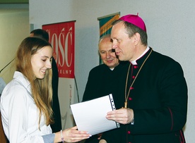  Bp Piotr Turzyński wręcza dyplom Aleksandrze Lasek, laureatce konkursu. Obok ks. Stanisław Łabendowicz, dyrektor Wydziału Katechetycznego kurii 