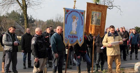 Chorągwiarze z Parmy modlą się przed przydrożnym krzyżem