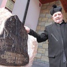 Ks. Marian Stach obok kamienia z płaskorzeźbą, będącą materialną pamiątką rocznicy chrztu Polski
