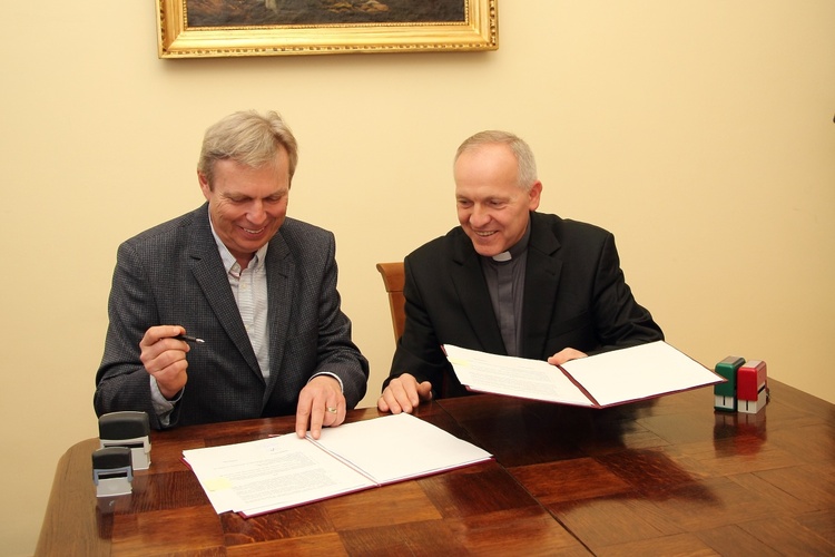 Krzysztof Terka i ks. Bogumił Karp podpisują umowę o remoncie parafialnego kompleksu