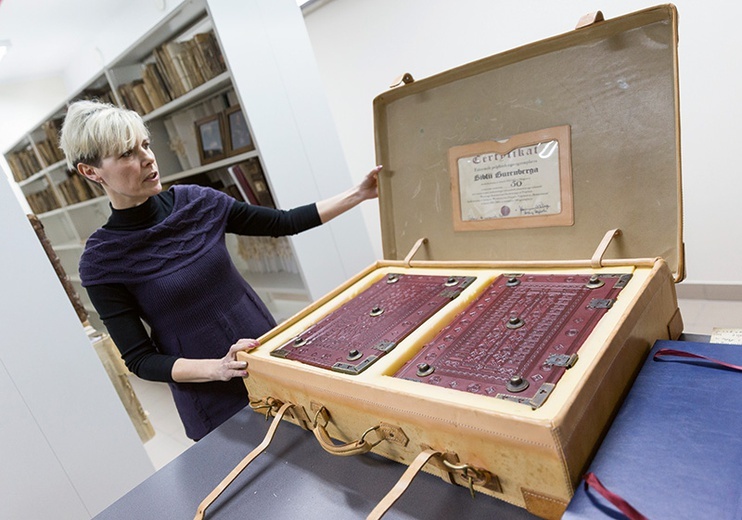 Renata Sikorska z Biblioteki Diecezjalnej pokazuje faksymile Biblii Gutenberga