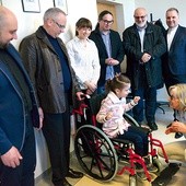  Na wózku 8-letnia Klaudia, podopieczna Stowarzyszenia „Budujemy Przystań” współpracującego z radomską Caritas. Przed nią Christina Flessner, za wózkiem mama Klaudii. Stoją Rycerze Kolumba, pracownicy Caritas i stowarzyszenia 