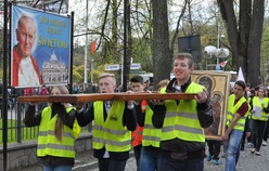 Procesja ze znakami. W tle obraz św. Jana Pawła II, patrona Światowych Dni Młodzieży