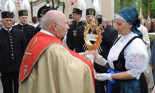 Ks. proboszcz Oskar Kuśka podaje do uczczenia relikwie św. Jana Pawła II przedstawicielom parafian
