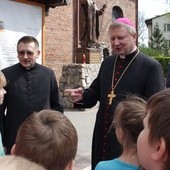 Biskup Wiesław Szlachetka w czasie rozmowy z najmłodszymi uczestnikami spotkania w Trąbkach Wielkich